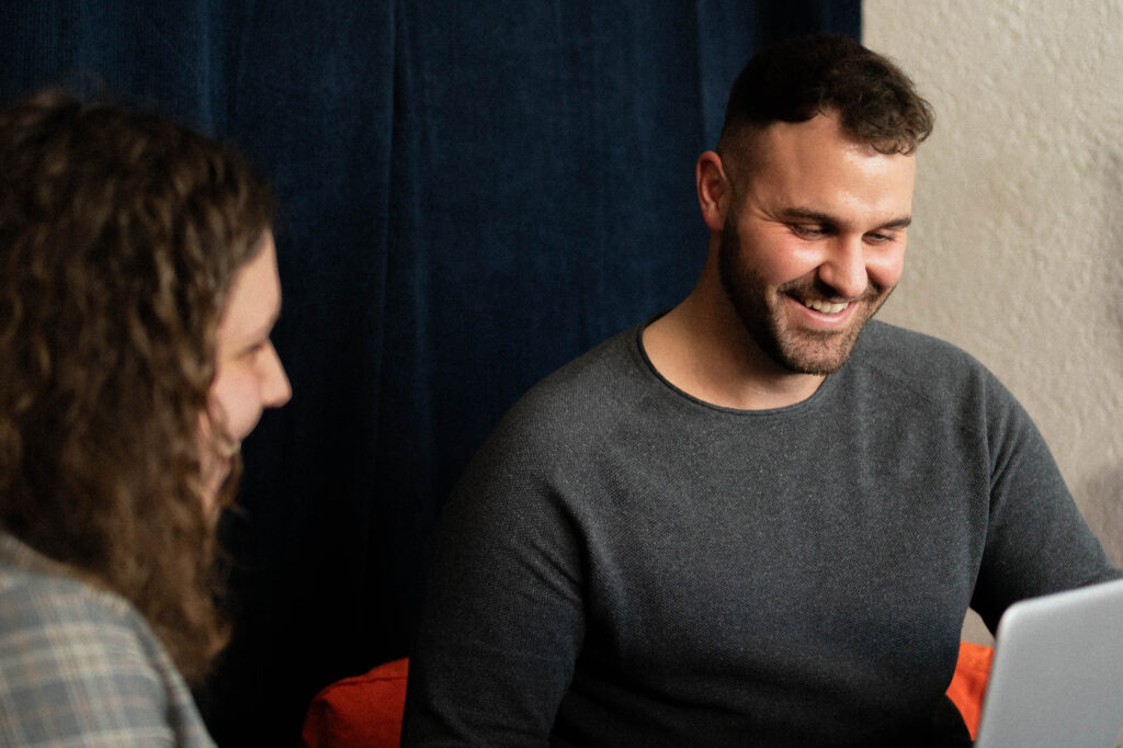 kollegen lachen vor laptop
