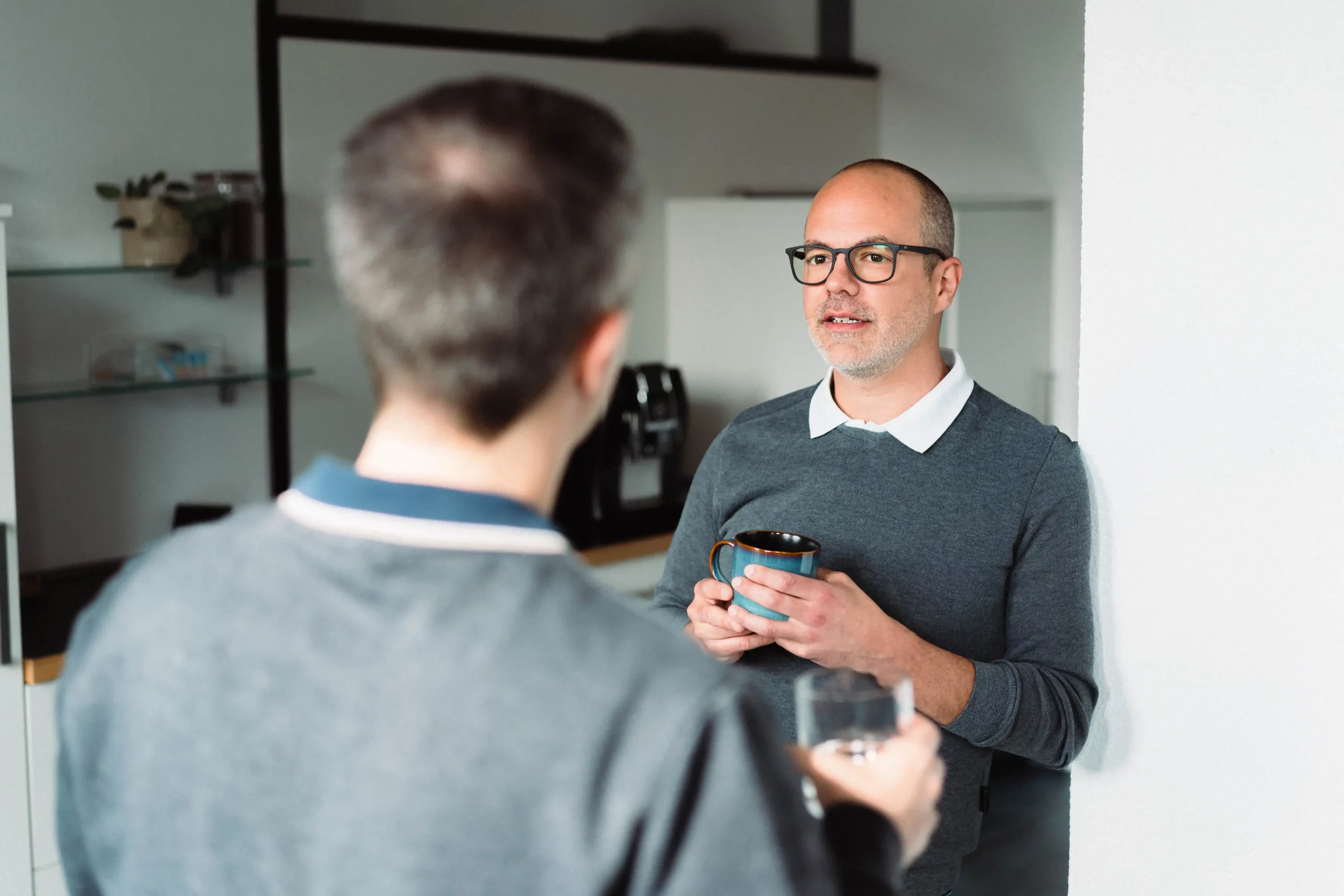 Zwei Männer stehen in einem Büro und unterhalten sich