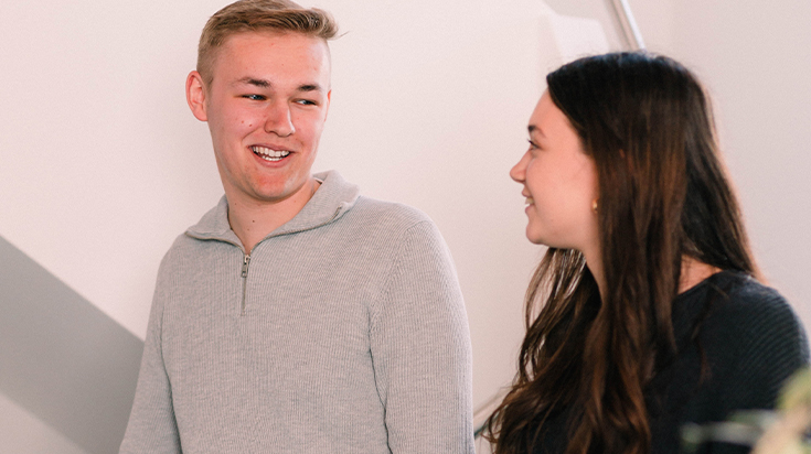 Zwei Duale Studenten laufen Treppe herunter und laecheln